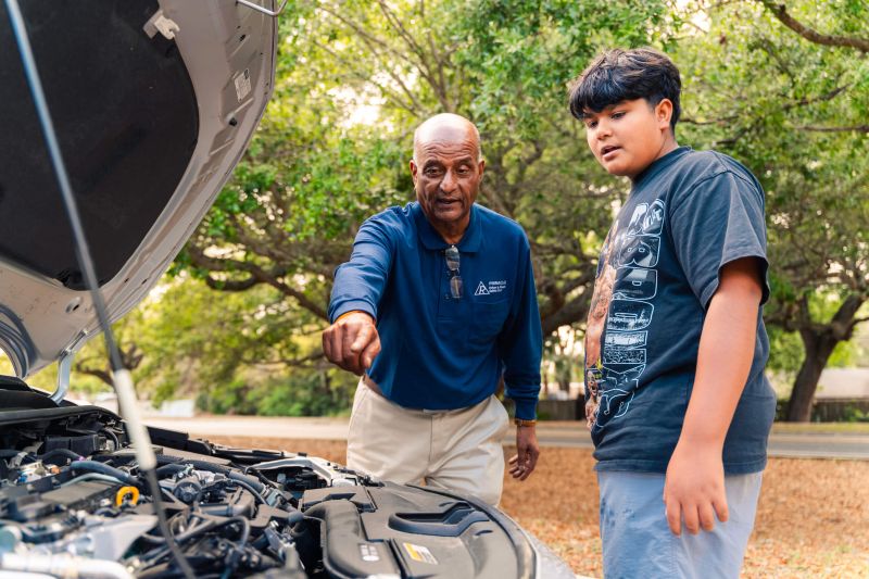 Driving instructor teaching student car basics