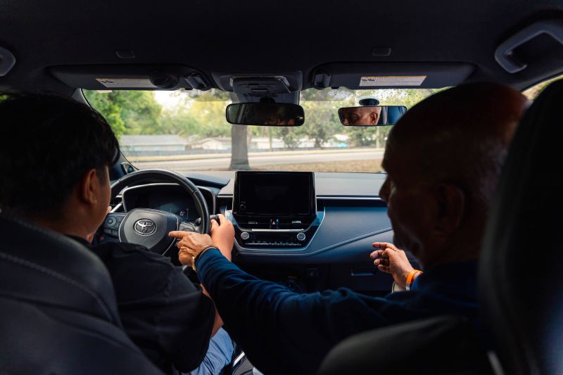 Driving instructor guiding student during road test practice