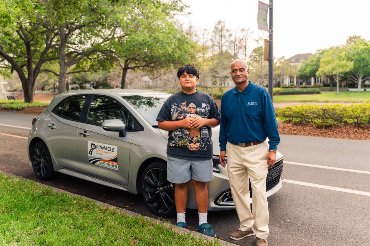 Pinnacle Driving School owner standing with student beside car